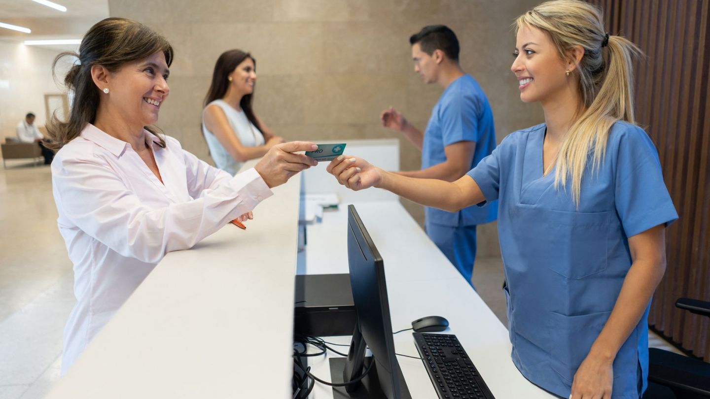 A woman handing out European Health Insurance Card  to a nurse
